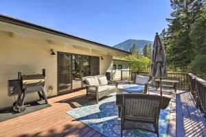 a deck with a piano and chairs and an umbrella at Renovated Riverfront Missoula Home with Deck! in Missoula
