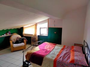 1 dormitorio con 1 cama, 1 silla y 1 ventana en Patty's Penthouse, en Cepagatti