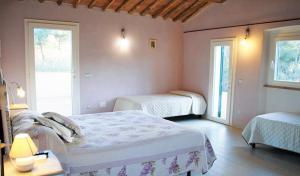 a bedroom with two beds and two windows at Hotel Gli Acquerelli in Portoferraio