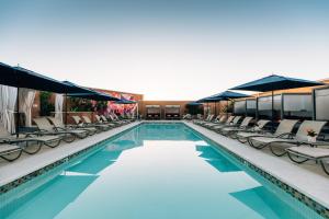 a swimming pool with chaise lounges and chairs at Four Seasons Hotel Silicon Valley at East Palo Alto in Palo Alto