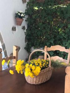 une corbeille de fleurs jaunes assise sur une table dans l'établissement Villa Aurelia - Casa de campo con jardín y piscina entre Madrid y Segovia, à Ortigosa del Monte