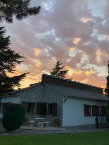 un edificio con una mesa de picnic delante de él en Villa Aurelia - Casa de campo con jardín y piscina entre Madrid y Segovia, en Ortigosa del Monte