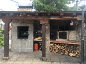 een gebouw met een stapel hout en een fornuis bij Villa Aurelia - Casa de campo con jardín y piscina entre Madrid y Segovia in Ortigosa del Monte