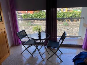 Una mesa y dos sillas frente a una ventana. en Heliocentro II -JÚPITER EN EDIFICIO REMEDIOS, en Los Llanos de Aridane