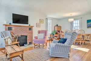 a living room with chairs and a fireplace at Charming Farmhouse Walk to Village and Trails! in East Burke