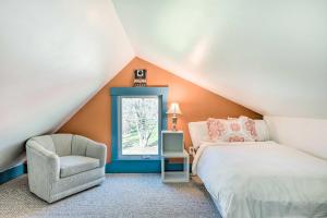 a attic bedroom with a bed and a chair at Charming Farmhouse Walk to Village and Trails! in East Burke