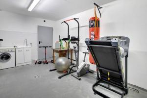 um quarto com um ginásio com uma televisão e uma máquina de lavar roupa em Olympic Chalet 12 em Bormio