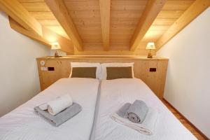 um quarto com uma cama com toalhas em Olympic Chalet 12 em Bormio