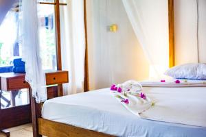 Un dormitorio con una cama con flores. en Art Hotel Zanzibar en Jambiani