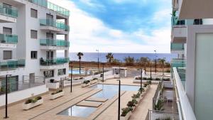 an image of a building with a swimming pool and the ocean at Dunas Beach II Apartment in Torrox Costa