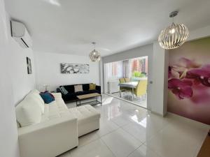 a living room with a white couch and flowers on the wall at Torre Colon in Benidorm