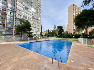 a swimming pool in a city with tall buildings at Torre Colon in Benidorm