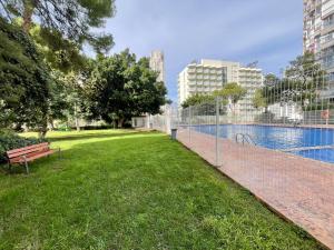 um parque com um banco ao lado de uma piscina em Torre Colon em Benidorm