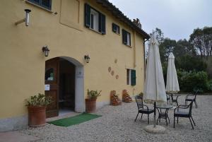 un edificio con sedie e un tavolo con ombrellone di Hotel Gli Acquerelli a Portoferraio