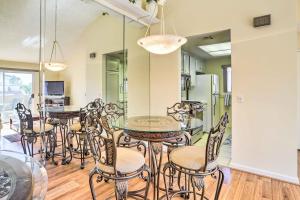 a dining room with a glass table and chairs at Steps to Pool and Spa Palm Desert Condo in Palm Desert