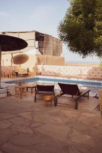 a swimming pool with a table and a picnic table at Izil Surfing Home in Imsouane