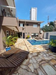 a house with a swimming pool next to a building at Hotel Casarão Pitangueiras in Guarujá
