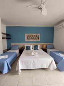 a bedroom with two beds and a blue wall at Hotel Casarão Pitangueiras in Guarujá +72 photos