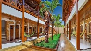 a room with a palm tree in the middle of a building at Jeri Hotel Group in Jericoacoara