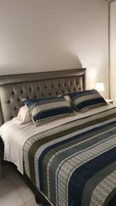 a large bed with two pillows on top of it at Apartamento Deluxe Senderos del Vino IV, Desayuno Opcional in Mendoza