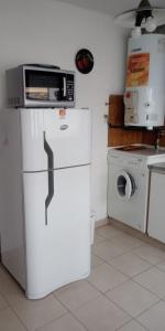een keuken met een magnetron en een koelkast bij Marbella 4 in Puerto Madryn