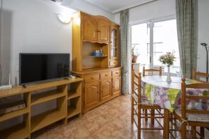 a living room with a television and a dining room table at Alegria ID40 in Torrevieja