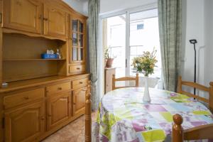 a kitchen with a table with a vase of flowers on it at Alegria ID40 in Torrevieja