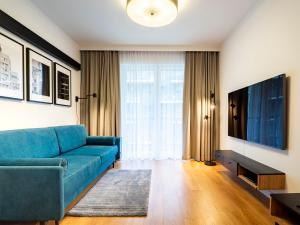 弗次瓦夫的住宿－City Comfort Wrocław，客厅配有蓝色的沙发和电视