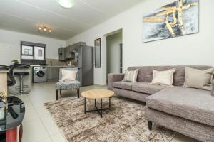 un soggiorno con un divano e un tavolo di The Quintessential getaway a Midrand