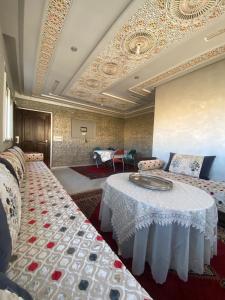 ein Wohnzimmer mit einem Tisch und einem Sofa in der Unterkunft Ayah's Vacation Home in Sidi Yahia az Zaʼer