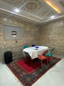 einen Tisch und Stühle in einem Zimmer mit einer Leinwand in der Unterkunft Ayah's Vacation Home in Sidi Yahia az Zaʼer