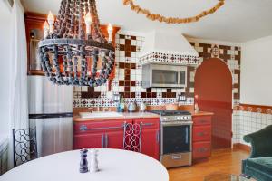 una cocina con armarios rojos y una lámpara de araña en Cozy & Equipped Spanish-Style Casita in Berkeley apts, en Berkeley