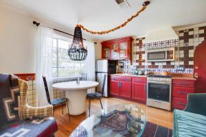 una cocina con armarios rojos y una mesa. en Cozy & Equipped Spanish-Style Casita in Berkeley apts, en Berkeley