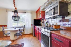 cocina con armarios rojos y fogones en Cozy & Equipped Spanish-Style Casita in Berkeley apts, en Berkeley