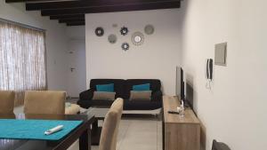 a living room with a couch and a table at Apartamento Deluxe Senderos del Vino I, con cochera incluida, Desayuno opcional in Mendoza