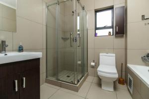 un bagno con doccia, WC e lavandino di The Quintessential getaway a Midrand