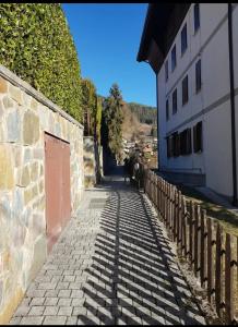 a stone path next to a building and a wall at Casa Vacanza IL CICLAMINO in Borno