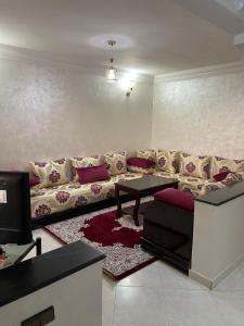 Villa a tamaris dar bouazza في الدار البيضاء: غرفة معيشة مع أريكة وطاولة