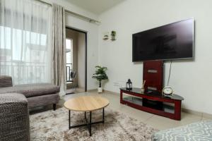 un soggiorno con una TV a schermo piatto su una parete di The Quintessential getaway a Midrand