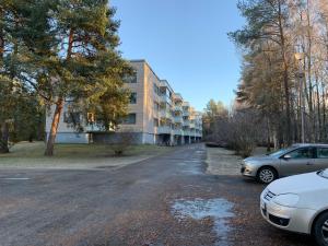 an empty street with cars parked in front of a building at 2BR Apartment, free parking - Peikontie in Oulu