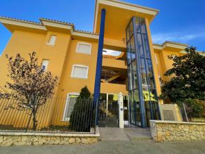 un edificio amarillo con una valla delante en Alpen1 Nerea, en Peñíscola