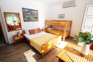 ein Schlafzimmer mit einem Bett und einem Etagenbett in der Unterkunft Apartmani Kukoljac in Herceg-Novi