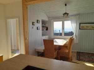 a dining room with a table and chairs and a window at Minihaus in den Bergen/ Small mountain house in Greith
