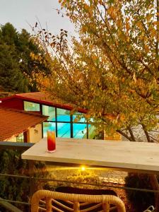 a wooden table with a candle and a drink on it at Boutique Hotel Skamnos Arachova in Arachova