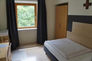ein kleines Schlafzimmer mit einem Bett und einem Fenster in der Unterkunft Kloster Neustadt in Neustadt an der Weinstraße