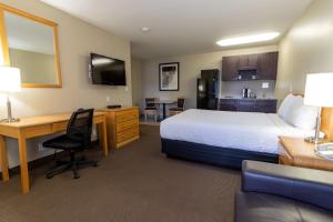 a hotel room with a bed and a desk with a computer at BCMInns - Hinton in Hinton