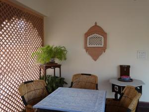 una sala da pranzo con tavolo e sedie in vimini di Badnor House - The Heritage Homestay a Ajmer