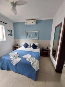 1 dormitorio con 1 cama con toallas en Hotel Casarão Pitangueiras, en Guarujá