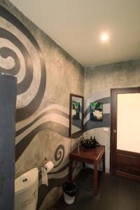 夜功府的住宿－River CoCo @ Amphawa，一间带卫生间和壁画的浴室