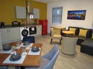cocina y sala de estar con mesa y sillas en Eazy apartments, en Newcastle